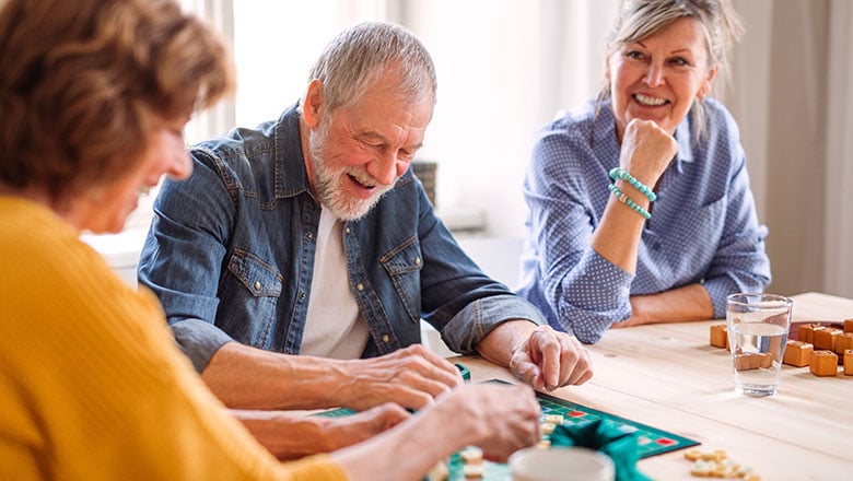 Group of senior people playing board games in community center club