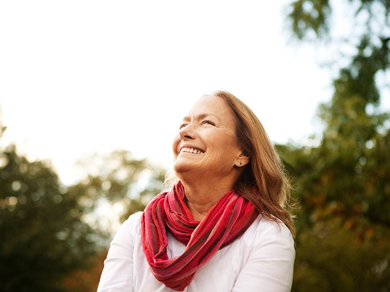 Happy senior woman looking up at Prospect Park