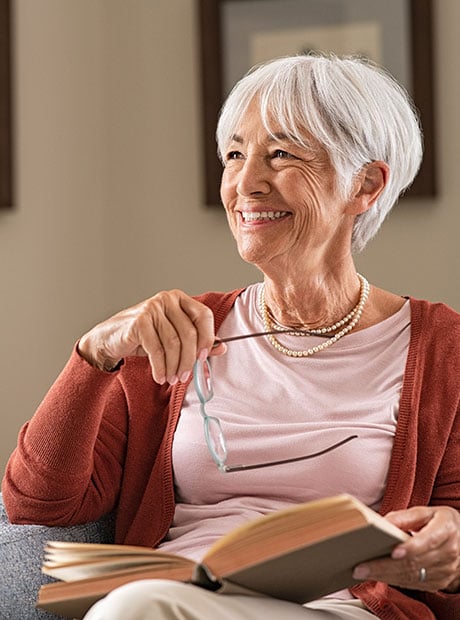 Senior lady smiling while reading a book