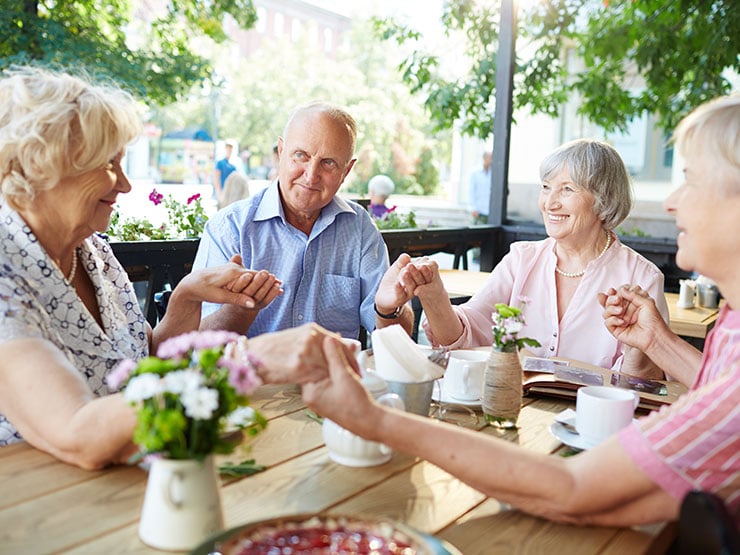 Senior people holding hands at the table