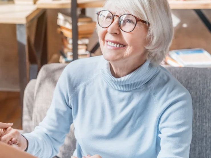 Senior woman holding hands with someone