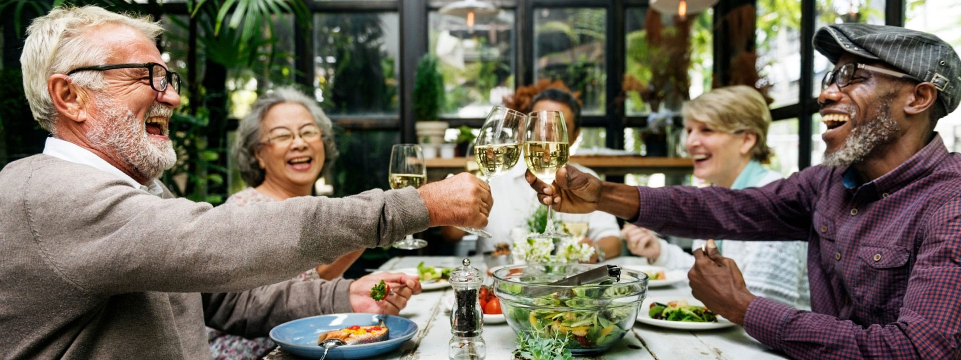 senior friends toasting at a table