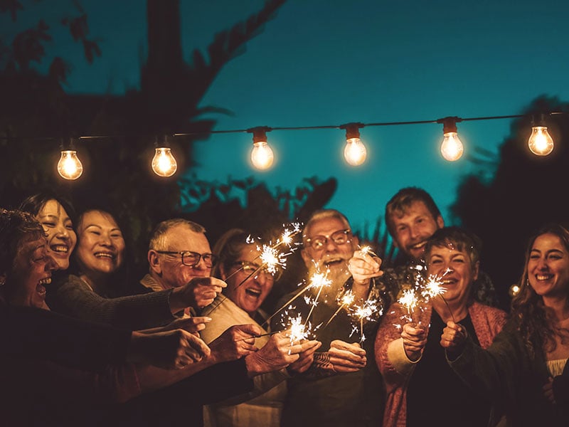 Senior friends with sparkles at night