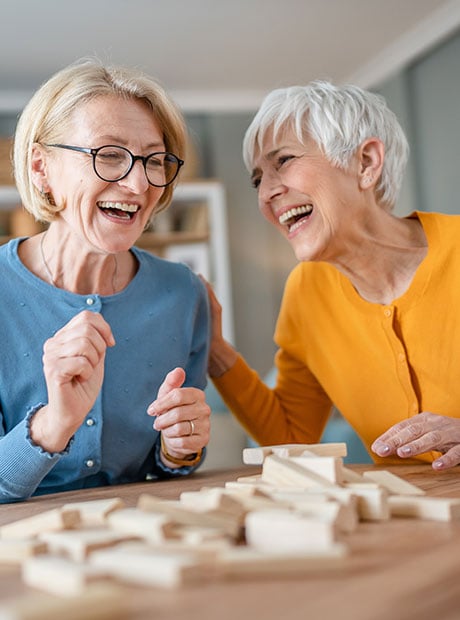 two senior women friends playing board games