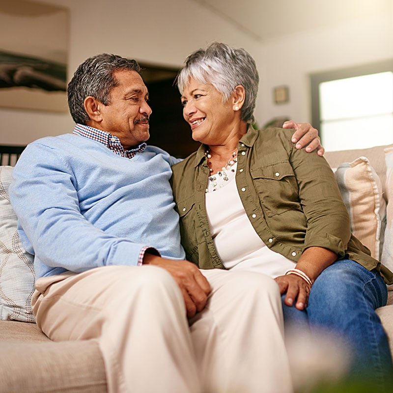 A senior couple smiling at each other.