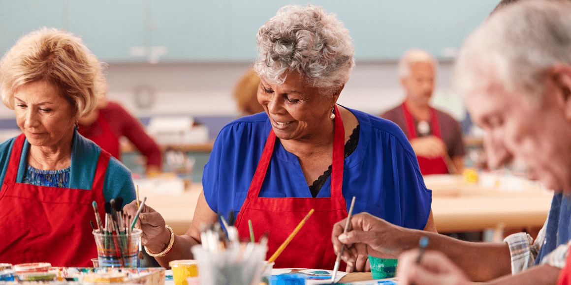 Retired senior woman attending art class in community centre