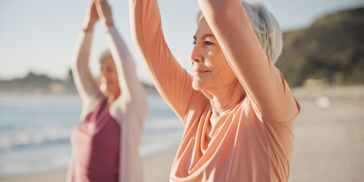 Yoga, meditation and senior women, stretching and fitness on beach for wellness, exercise and pilates training