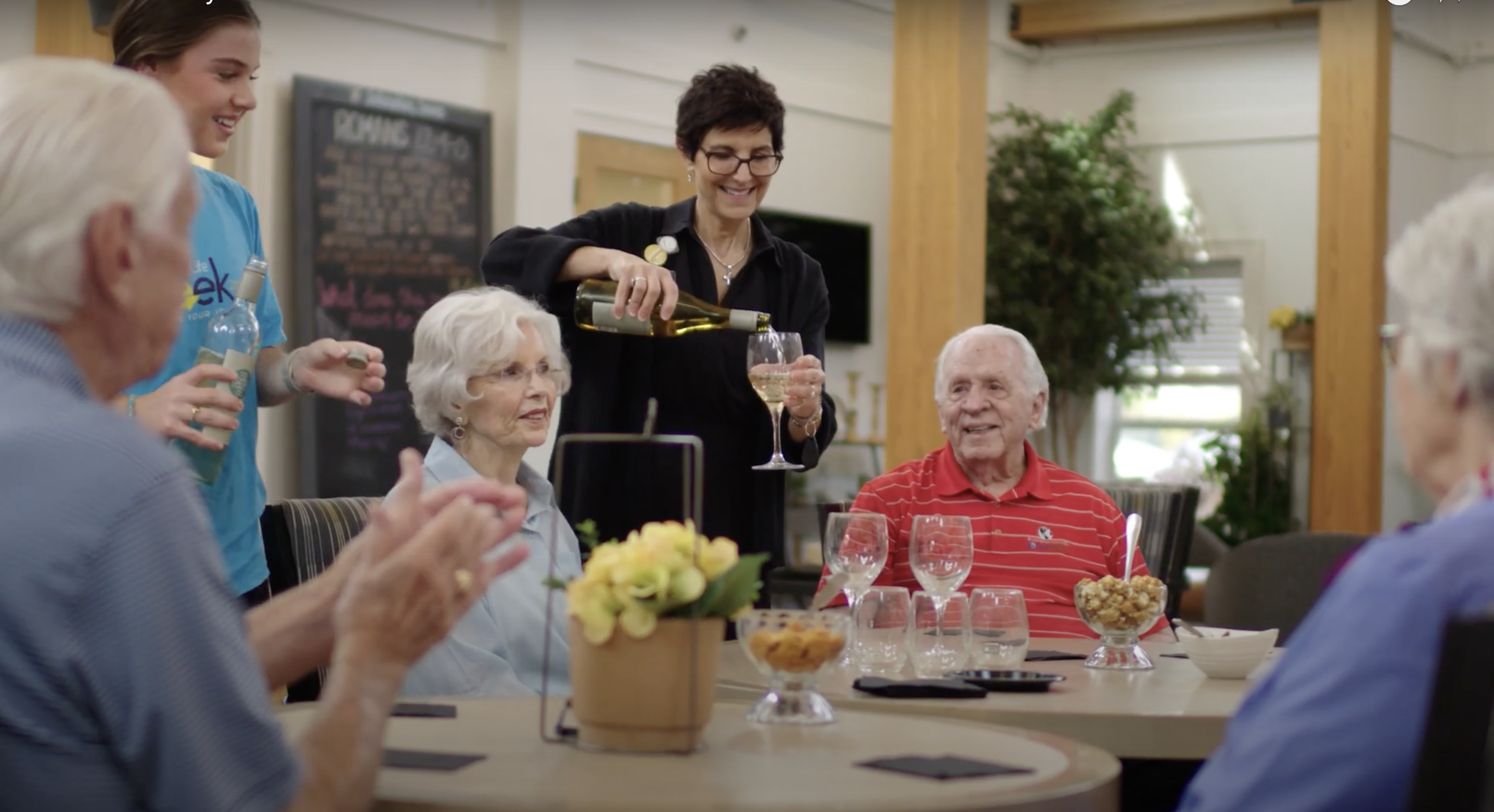 A group of seniors sitting around a table drinking wine