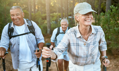 Two men and a woman hiking outdoors.